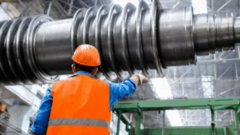 man in an orange safety vest and helmet with his back to camera checking quality, ensuring he will build it right just like continuous testing in devops