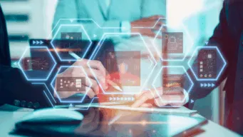 mid-bosy shot of three office workers around laptop with devops vs devsecops icons floating above the keyboard: security, process, etc icons.