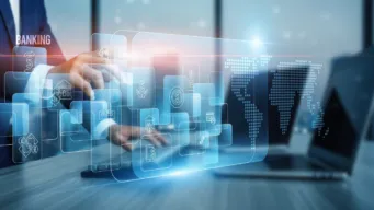 mid-shot of a male working at a laptop in a high office building with SWIFT connectivity icon floating over keyboard