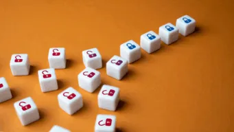 a cluster of dice marked with open red locks lay on a wooden table on the left, but on the right, they are organized in a line and are marked with closed blue locks, showing how robust test management aligns and secures software test management