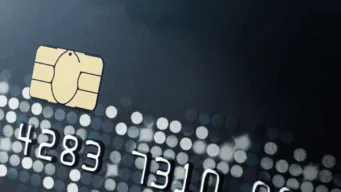 Close-up of a credit card with EMV chip and embossed numbers, representing PCI DSS compliance and VAPT security testing for payment card environments.