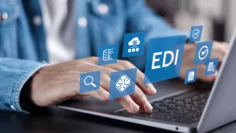hands typing on a keyboard with graphics that read "EDI" floating above it
